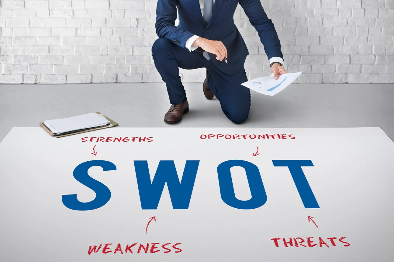 เจ้าของธุรกิจกำลังอธิบายว่า SWOT คืออะไร ให้ทีมการตลาดในบริษัทฟัง